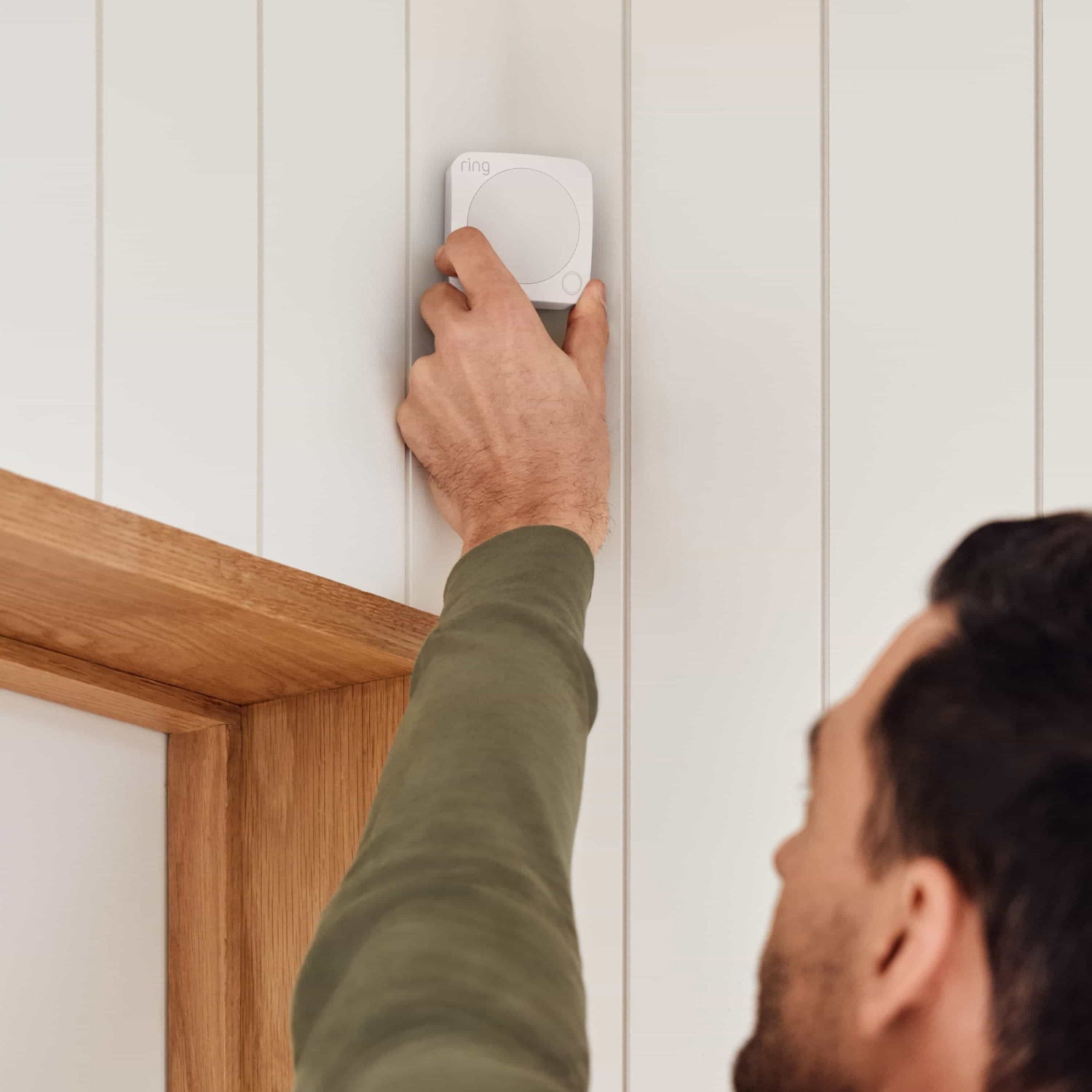 8-Piece Alarm Security Kit + Indoor Cam (2nd Gen) - Man installing a Ring Alarm Motion Detector above a doorway, showing easy setup of 8-Piece Alarm Security Kit.
