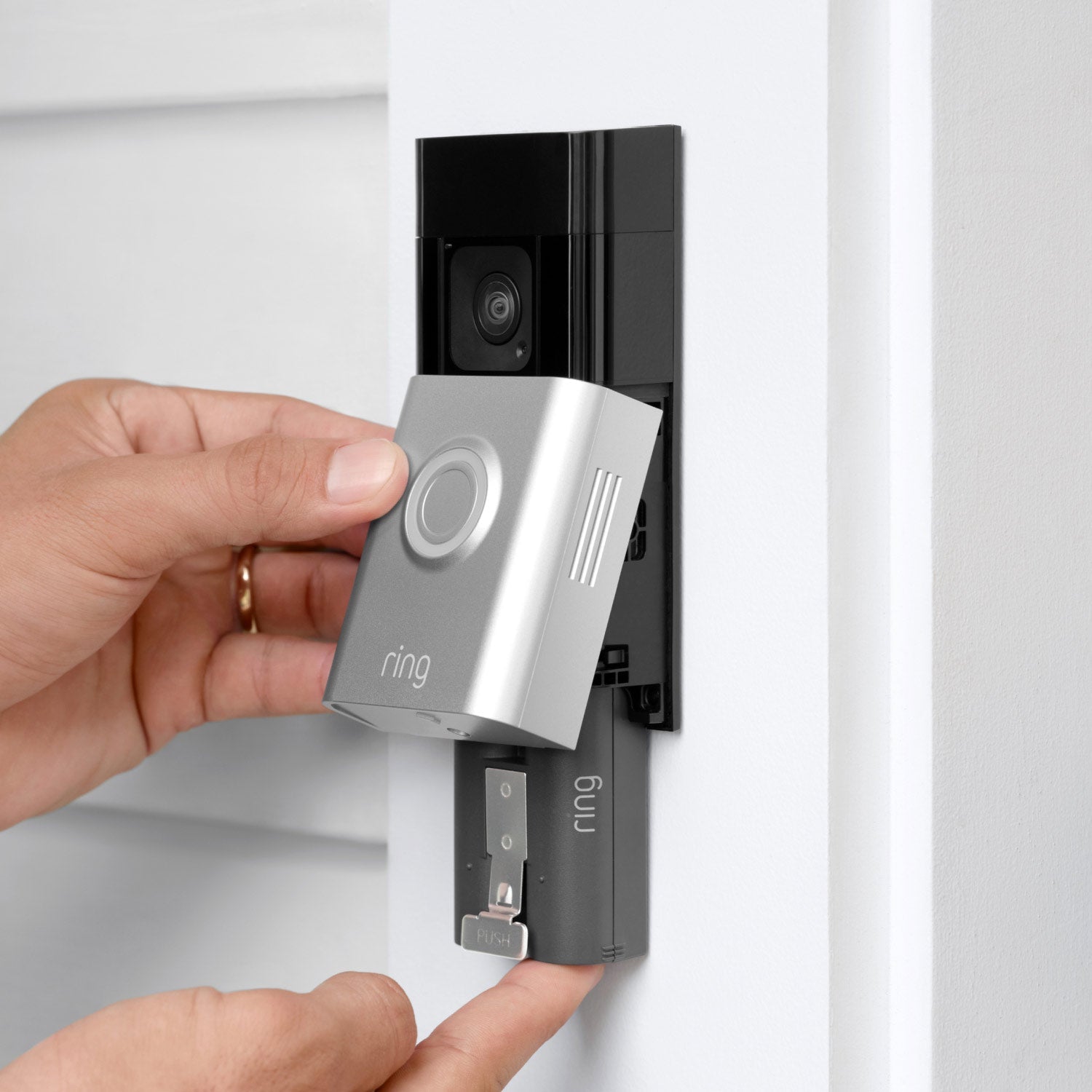 Battery Doorbell Plus (Video Doorbell) (Certified Refurbished) - Hands removing Ring Battery Doorbell Plus faceplate on a door frame to access rechargeable quick-release battery pack.