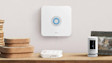 Ring Alarm Base Station, a white Ring security camera, and a Ring Alarm Keypad on a wooden surface